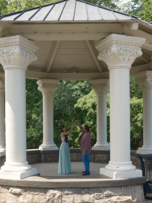 Shyamli and Amey dancing together beneath a garden pavilion